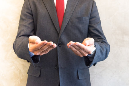 Businessman holding something on the palm of his hand, business conceptの写真素材