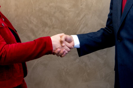 Businessman and businesswoman shaking hands to seal a deal or cooperationの写真素材