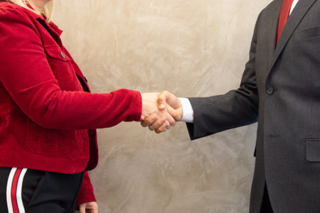 Businessman and businesswoman handshaking after good deal, closeupの写真素材