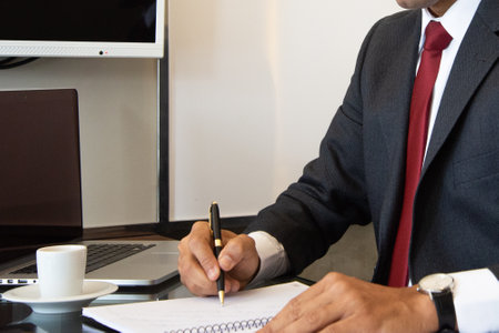 Businessman writing on notepad at office desk. Business concept.の写真素材