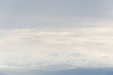 Cloudy sky with some mountains peeking between clouds, in the Colombian Andesの写真素材