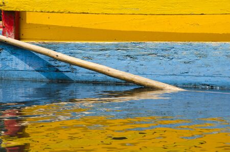 Colorful frame: detail of yellow, blue and red Trajinera boat and its reflection, in Xochimilco, Mexicoの写真素材