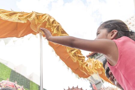Capital Federal, Buenos Aires / Argentina; Jan 25, 2020: Little girl trying to touch a golden dragon...