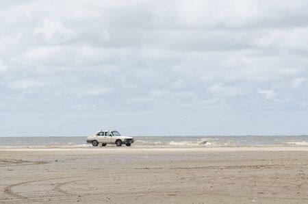 Beach landscape, a car standing in the sand with the sea in the background, in Punta Rasa, Province of Buenos Aires, Argentinaの写真素材