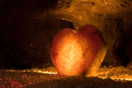 Nemocon, Cundinamarca / Colombia; March 24, 2018: huge salt crystal sculpted in the shape of a heart and illuminated with a warm light, inside a salt mineのeditorial素材