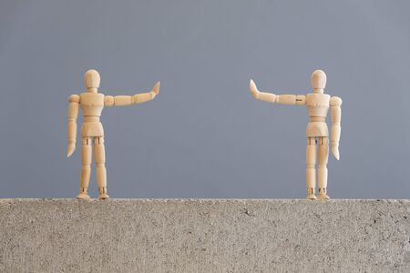 Image about social distancing, mandatory due to the coronavirus outbreak, covid-19. Pair of wooden human figures standing at a safe distance from each other.の写真素材