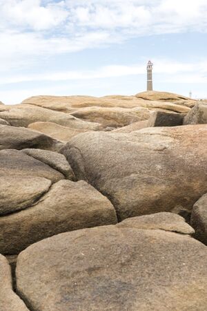 Coastal rocks and lighthouse in Cabo Polonio, Uruguay, a summer dayの写真素材