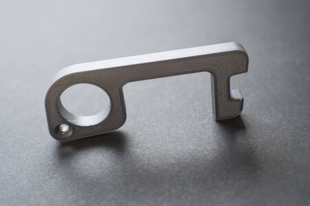 Plastic tool made in 3d printer to open doors and press buttons without touching them, to avoid the spread of the coronavirus disease, Covid-19. New normal.の写真素材