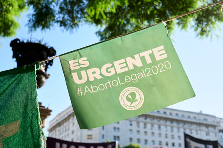 Buenos Aires, Argentina; Dec 10, 2020: Poster in defense of the legal, safe and free abortion law, at a massive rally in front of the National Congress. Text It is urgent.のeditorial素材