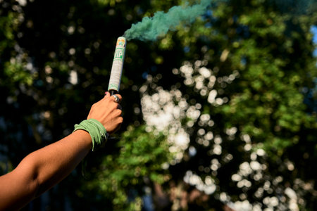 Buenos Aires, Argentina; Dec 10, 2020: detail of a demonstration at the National Congress, defending the approval of the legal, safe and free abortion law. Woman raising a symbolic green smoke bomb.のeditorial素材
