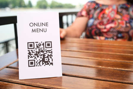 Table with a QR code for contactless access to the digital menu of the restaurant by scanning it,...