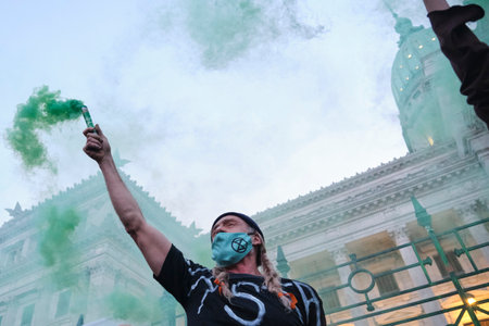 Buenos Aires, Argentina; Sept 24, 2021: Global Climate Strike, activist with one arm raised raising...