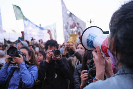 Buenos Aires, Argentina; Sept 24, 2021: Global Climate Strike, young female activist use a megaphone to speak to a crowd about the climate crisis. Photographers and journalists record the situation.のeditorial素材