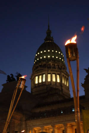 Torches lit during a protest at night in Buenos Aires, Argentina. In the background, the dome of the National Congress.の写真素材