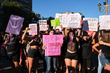 Buenos Aires, Argentina; March 8, 2022: Women holding signs during the international feminist strike: Being alive should not be an achievement; Be thankful that we are asking for justice, not revenge.のeditorial素材