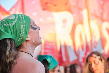 CABA, Buenos Aires, Argentina; March 8, 2022: International feminist strike. Young woman wearing a green handkerchief, symbol of legal abortion support.のeditorial素材