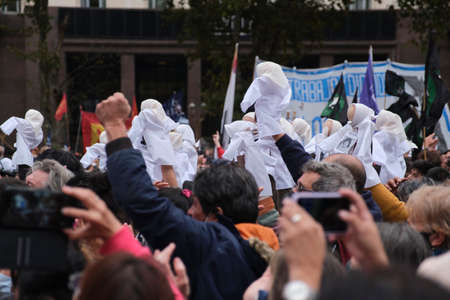 Buenos Aires, Argentina; March 24, 2022: National Day of Remembrance for Truth and Justice, crowd, people raising their arms and puppets representing the Mothers of Plaza de Mayo.のeditorial素材