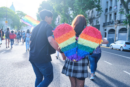 Buenos Aires, Argentina; Nov 6, 2021: LGBT Pride Parade. Young people marching towards the Congress seen from behind, woman with rainbow colored wings.のeditorial素材