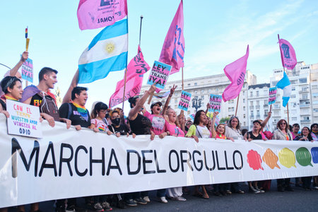 Buenos Aires, Argentina; Nov 6, 2021: LGBT Pride Parade. Group of people marching holding a banner with the text Pride March and persons with posters, Comprehensive trans law now.のeditorial素材