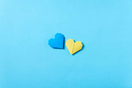 Blue and yellow origami hearts, colors of the Ukrainian flag. Conceptual symbolic image in support of this country during the Russian military invasion. Solidarity, peace for Ukraine.の写真素材