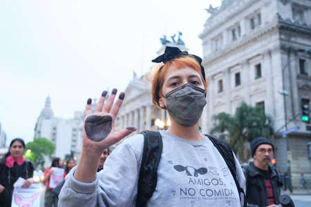 Buenos Aires, Argentina; Nov 1, 2021: World Vegan Day, activists marching in front of Congress. Young woman with her hand painted like an animal paw and a message on her clothes: friends, not food.のeditorial素材