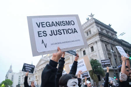 Buenos Aires, Argentina; Nov 1, 2021: World Vegan Day. activists marching in front of the National Congress holding signs with animalist messages: Veganism is justice.のeditorial素材