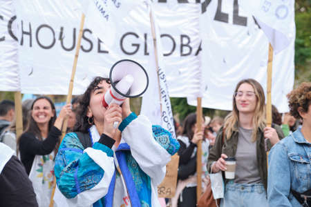 Buenos Aires, Argentina; April 22, 2022: Young activist with a megaphone shouting, cheering on an environmental collective during the Earth Day demonstration.のeditorial素材