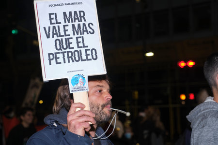 Buenos Aires, Argentina; May 21, 2022: Environmental activism, man protesting against oil exploration and exploitation in the oceans. Poster: The sea is worth more than oil.のeditorial素材