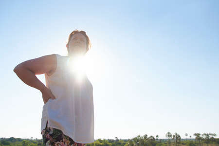 Portrait of mature Hispanic woman at sunset. Natural outdoor portrait with copy space. Concept: empowered confident woman who enjoys an active life in connection with nature.の写真素材