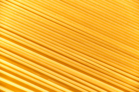 Italian food background, raw spaghetti filling the frame in a textured design of diagonal pasta lines.の写真素材