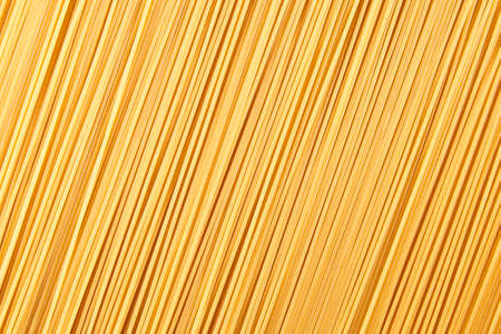 Italian food background, raw spaghetti filling the frame in a textured design of diagonal pasta lines.の写真素材