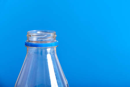 Top of an empty plastic transparent disposable bottle and blue background. Concepts: sustainability, recycling, pollution, zero waste campaigns.の写真素材