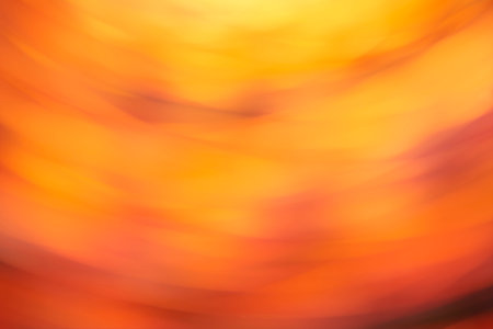 Orange blur background, abstract dynamic colorful flowing design, vivid warm lights in spin motion.の写真素材