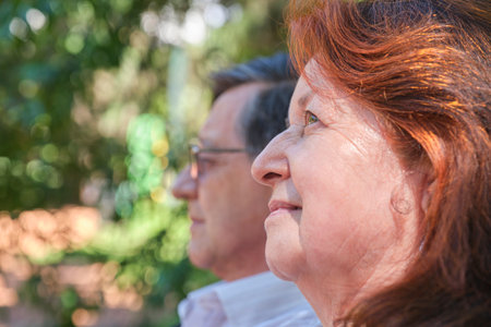 Senior Hispanic couple enjoying time together in a park, outdoors. Selective focus on her. Concepts:...