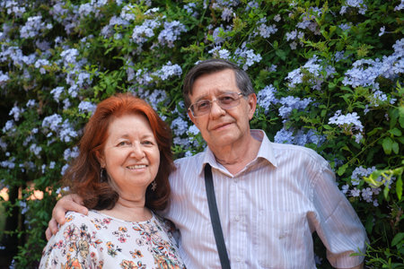 Portrait of a senior Hispanic couple looking at camera in a natural environment, a spring flowering garden. Concepts: enjoyment of nature, active retirement.の写真素材