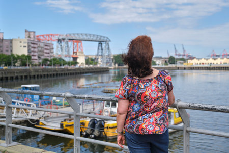 Mature latin woman taking a selfie with her smartphone in the touristic neighborhood of La Boca, in Buenos Aires, Argentina, on a sunny summer day.の写真素材