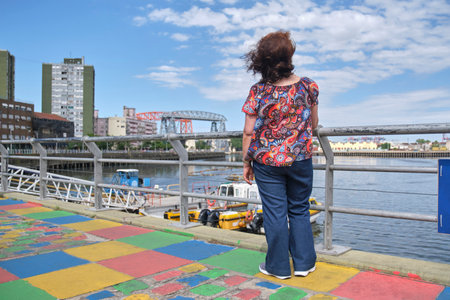 Mature latin woman taking a selfie with her smartphone in the touristic neighborhood of La Boca, in Buenos Aires, Argentina, on a sunny summer day.の写真素材