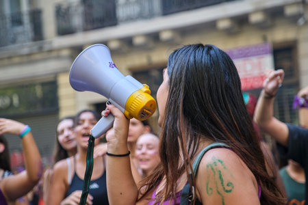 Buenos Aires, Argentina; March 8, 2023: Woman singing, cheering her peers using a megaphone during the international feminist strike. Concepts of activism and social struggle for rights.のeditorial素材
