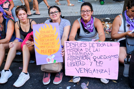 Buenos Aires, Argentina; March 8, 2022: Women holding posters: Why are you frightened by those who fight and not by those who die? After all the history, be thankful we demand freedom, not revenge!のeditorial素材