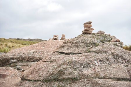 Pircas, piles of stones that serve as trail markers for hikers to follow the correct way, in Los Gigantes, Cordoba, Argentina. Nature travel concept.の写真素材