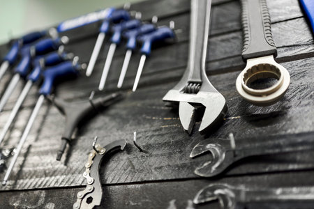 Wrenches and other hardware hanging on a tool board in a bicycle repair shop. Close up view with selective focus.の写真素材