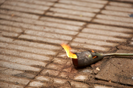 Lit blowtorch, throwing fire leaning on the ground. Composition without people with copy space.の写真素材