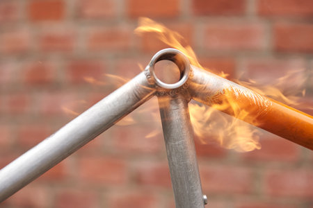 Manual bicycle renovation work, paint removal process using a blowtorch fire to change the color of a bike frame. Close up view.の写真素材