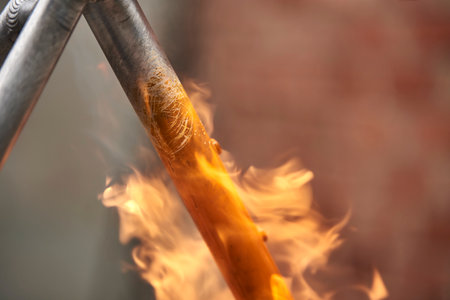 Manual bicycle renovation work, paint removal process using a torch fire to change the color of a bike frame. Close up view.の写真素材