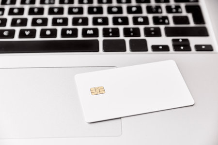 Blank white credit or debit card with microchip on a laptop. Concepts of plastic money and online shopping.の写真素材