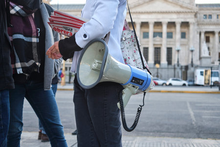 Buenos Aires, Argentina, Oct 5, 2023: protest against offshore oil exploitation. Woman with a megaphone hanging and holding a Prensa Obrera newspaper. Concepts: social and environmental protestのeditorial素材