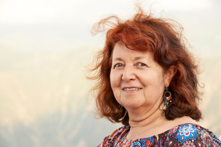 Candid portrait of a mature Hispanic woman smiling looking at the camera, natural background out of focus, composition with copy space.の写真素材