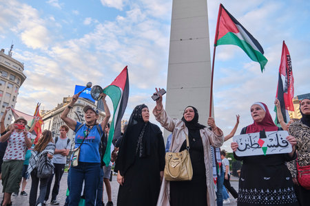 Buenos Aires, Argentina, Feb 16, 2024: People protesting in front of the obelisk, downtown, with pacifist posters and Palestinian flags in solidarity with Palestine and against Israel genocide attackのeditorial素材