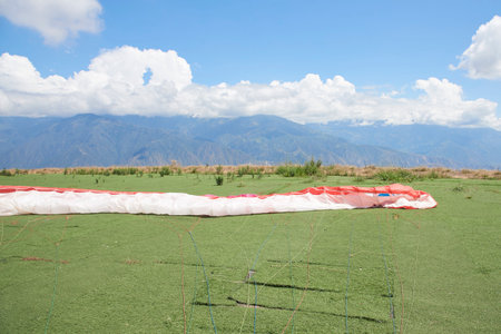 Paraglider wing extended on the ground, prior to a flight. Careful preparations are essential to...