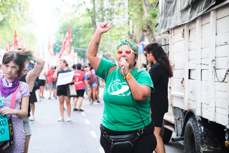Buenos Aires, Argentina; March 8, 2024: Woman chanting feminist slogans while marching during the international women strike wearing the green t-shirt of the campaign in defense of legal abortion.のeditorial素材